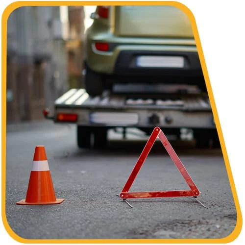 Verkehrskegel und Warndreieck sichern den Abschleppvorgang ab