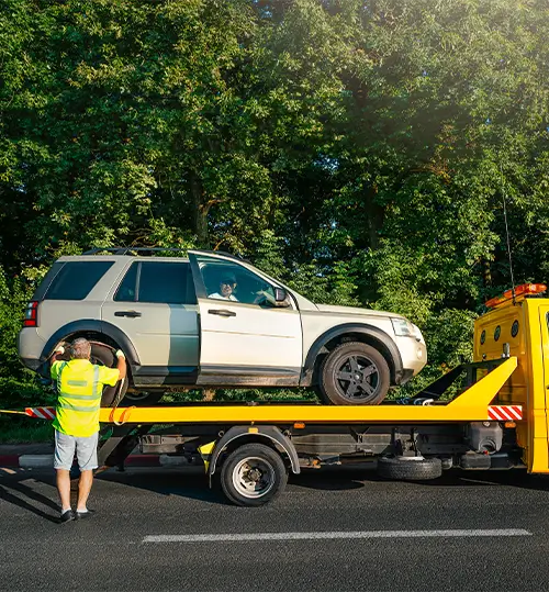 Mitarbeiter lädt einen Geländewagen auf den Abschleppwagen