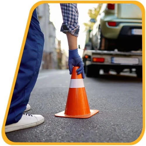 Mitarbeiter stellt einen Verkehrskegel zur Absicherung auf